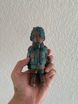 A hand holding a small figurine, UPRISING - damage from the space by Riclotoys.