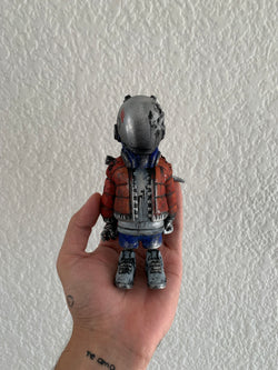 A hand holding a toy robot from UPRISING - Street fighter by Riclotoys.