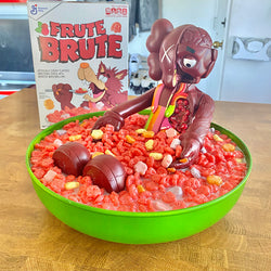 A bowl of cereal with a toy figurine inside, part of Misappropriated Icon 6 Eat Up - Frute Brute by Zard Apuya.