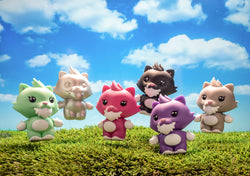 A group of small toy animals on grass, including a pink and purple cat toy, with a close-up of a toy in the air.