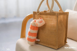 LuLu The Piggy Caturday plush keychain with Kitty and tail, chair with stuffed animal and bag.