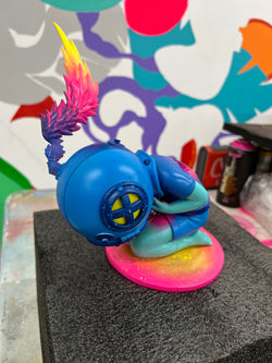 A hand-painted resin toy figurine of a diver with colorful wings.